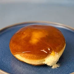 Donut Brulee com casquinha dourada de açúcar e creme de baunilha escorrendo
