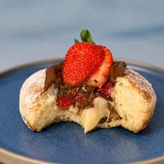 Donut Extraordinário mordido, com morango por cima