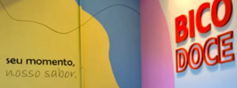 Parede colorida da loja Bico Doce com a frase seu momento, nosso sabor